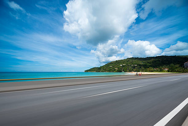 海の横にあるアスファルト道路、車の広告の背景 - coastline ストックフォトと画像