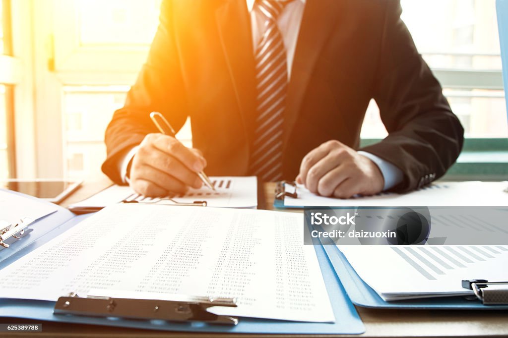 Businessman in the office Businessman analyzing financial statements in the office Financial Advisor Stock Photo