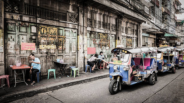 people and tuktuk taxi with background classic door. Bangkok, Thailand - September 9, 2016: Unidentified people and tuktuk taxi with background classic door in Yaowarat road,Bangkok capital city,Thailand. bangkok street stock pictures, royalty-free photos & images