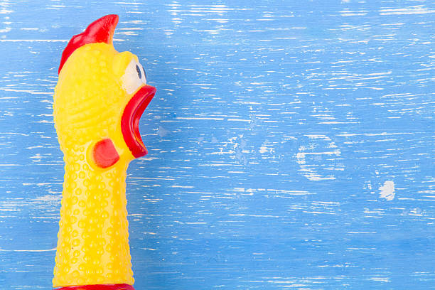 istock Toy yellow shrilling chicken on blue wooden background 625394740