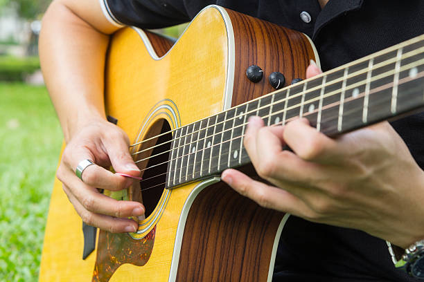 istock playing guitar in the park 625394772