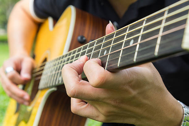 istock playing guitar in the park 625394816