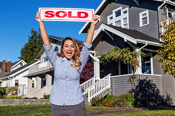 istock Attractive Young Hispanic Real Estate Agent with SOLD Sign 625395580