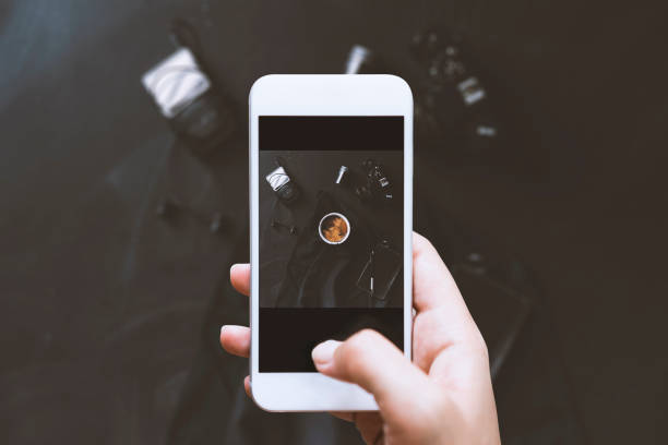 istock Hand using phone, photographing table top shot with coffee 625397440