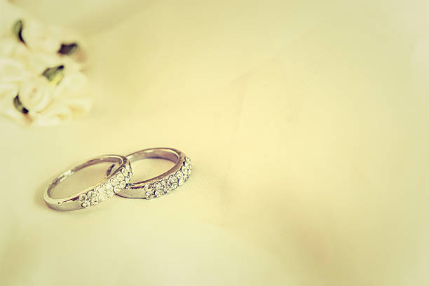 istock Two wedding rings laying on wedding dress 625407328