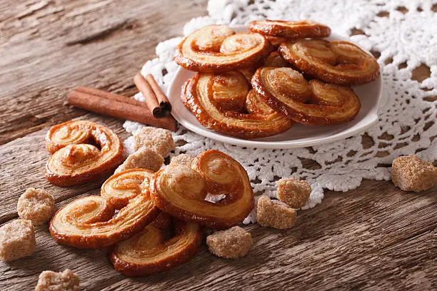 Palmiers biscuits with sugar and cinnamon on the table close-up, horizontal