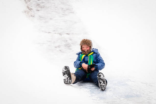istock Boy riding the ice slides in the winter 625411112