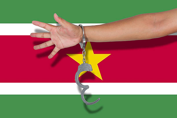 manette con mano su bandiera suriname - flag of suriname foto e immagini stock