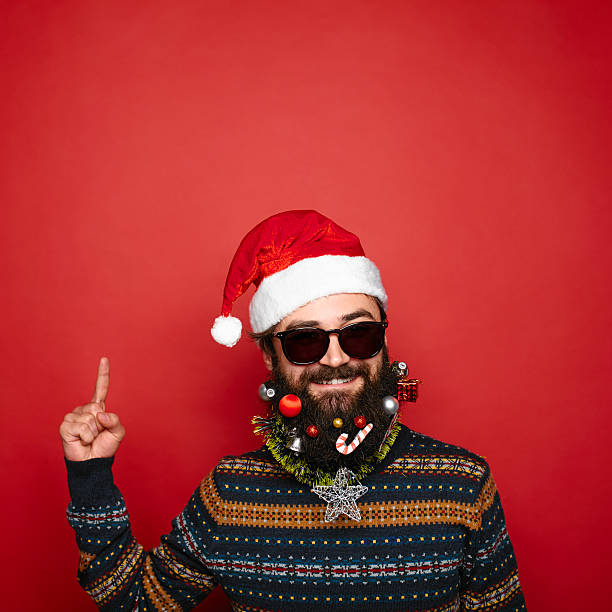 istock handsome new year man with decorated beard pointing up 625415810