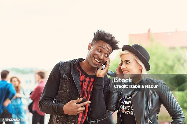 Funky Young Couple Listening To Music Outdoor Stock Photo - Download Image Now - 20-29 Years, Adult, African Ethnicity