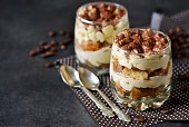 Classic tiramisu in a glass jar on the background chermon