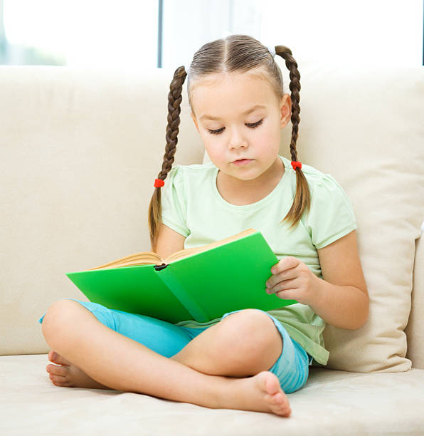 istock Little girl reads a book 625433828