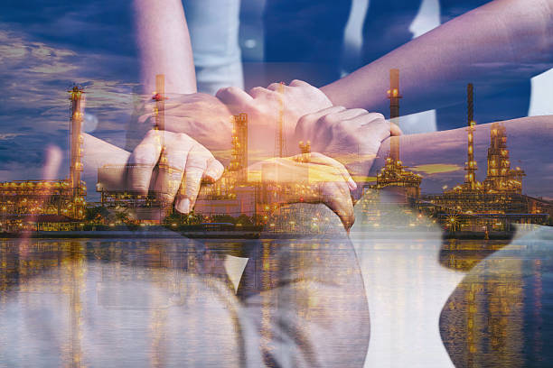 Double exposure of hands collaboration and oil refinery stock photo