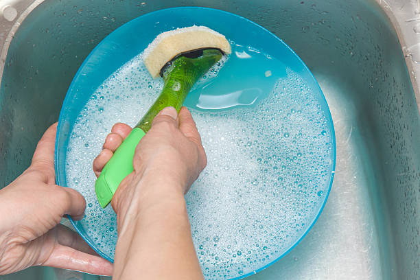 manos de la mujer usando esponja con vapor y lavando el tazón de plástico. - silverware clean wet kitchen utensil fotografías e imágenes de stock