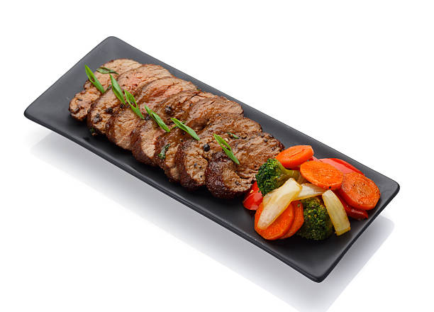 istock Roasted veal with vegetables on a black plate 625441804
