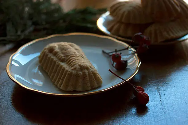 Gingerbread on a plate with red berries and fir-branches.