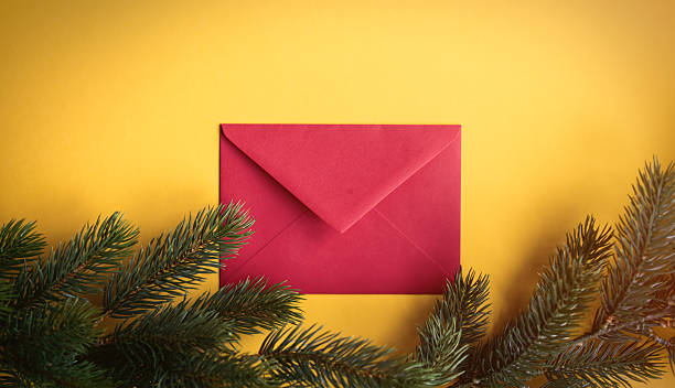 istock Red christmas envelope near a pine branch 625452268