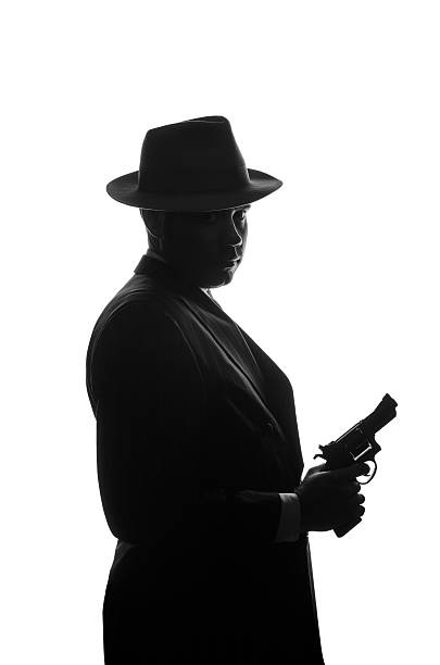 istock Silhouette of private detective with a gun in right hand 625452496