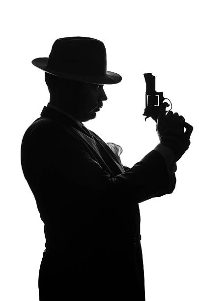 istock Silhouette of private detective with a gun in right hand 625452536