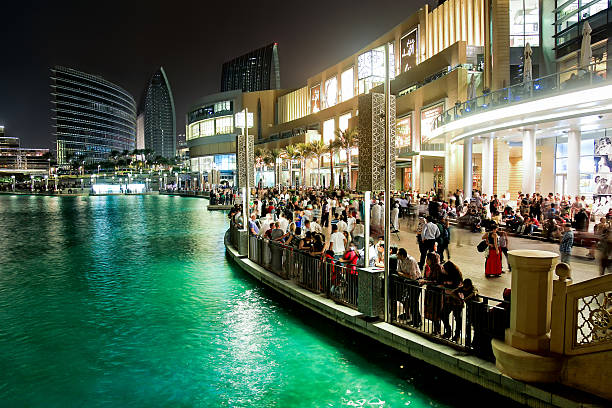 Crowd of people waiting for Dubai fountainÂ´s show Busy evening at Dubai downtown, Dubai Mall, Dubai fountain. People waiting for fountain to play its show. dubai mall stock pictures, royalty-free photos & images
