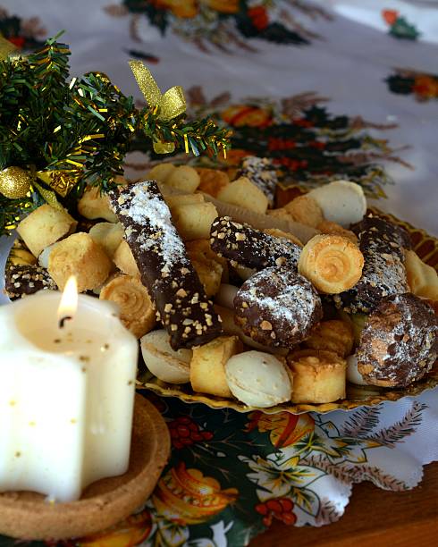 Christmas cookies on a plate and white lighted candle