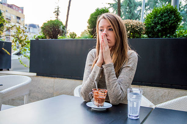 infeliz estressado linda fêmea sentada em café urbano moderno - overworked worried distraught front view - fotografias e filmes do acervo