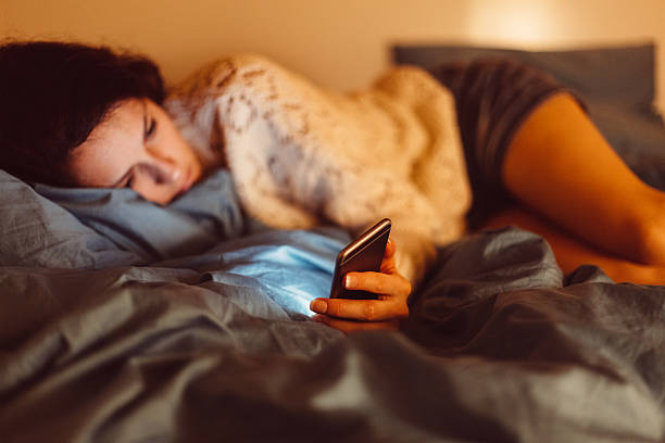 istock Low-spirited woman in bed text messaging 625458260