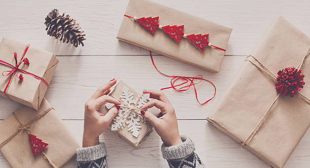 istock Woman's hands wrapping christmas holiday present with craft twine 625459616