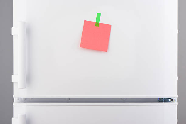 istock Pink paper note attached with green sticker on refrigerator 625466526