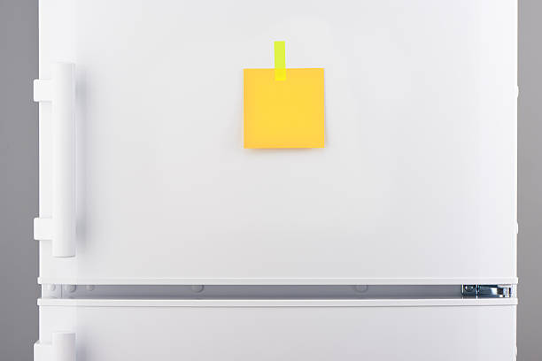 istock Yellow paper note attached with sticker on white refrigerator 625466688