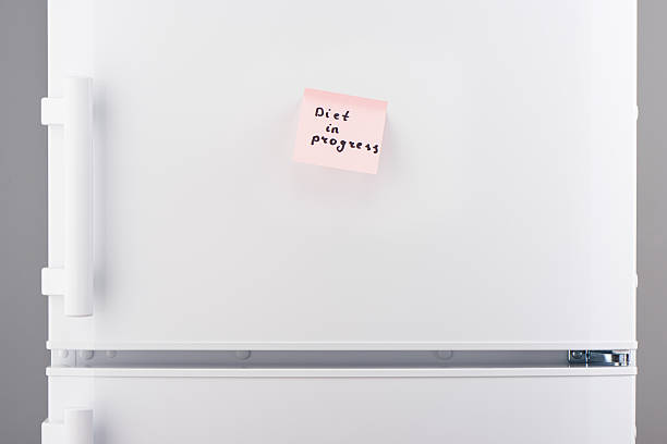 istock Diet in progress note on pink sticky paper on refrigerator 625467772