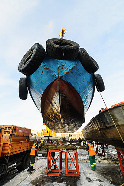 подъем судна из реки на зиму - barge beach large blue стоковые фото и изображения