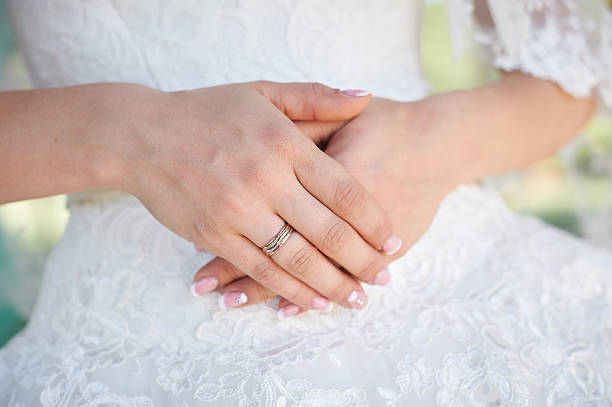 istock hands bride with gold ring on background of white dresses 625494226