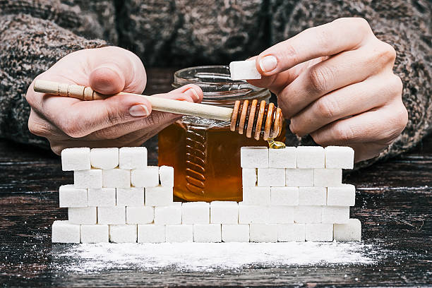 mains, miel et mur de sucre - place setting spoon silverware kitchen utensil photos et images de collection