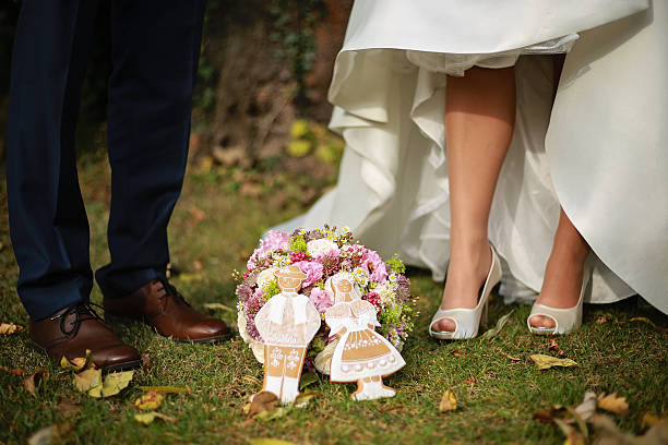istock Bride and groom feet with wedding bouquet and wedding gingerbread 625496826