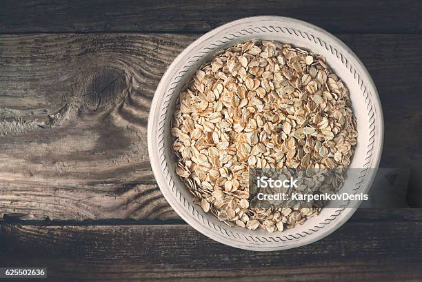 Raw Oatmeal In Bowl On The Wooden Table Top View Stock Photo - Download Image Now - Beige, Bowl, Breakfast