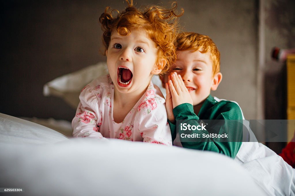 Morning Silliness Little girl and her older brother are being silly for the camera in the morning. They are in their pyjamas in their mother's bed. Child Stock Photo