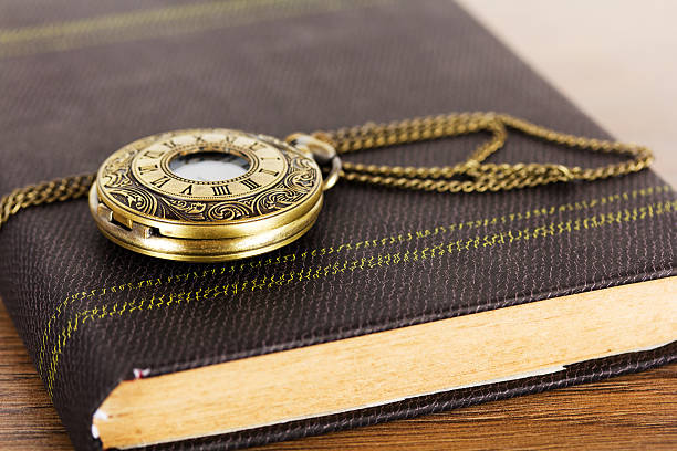 istock Pocket watch and book against a rustic background 625504954