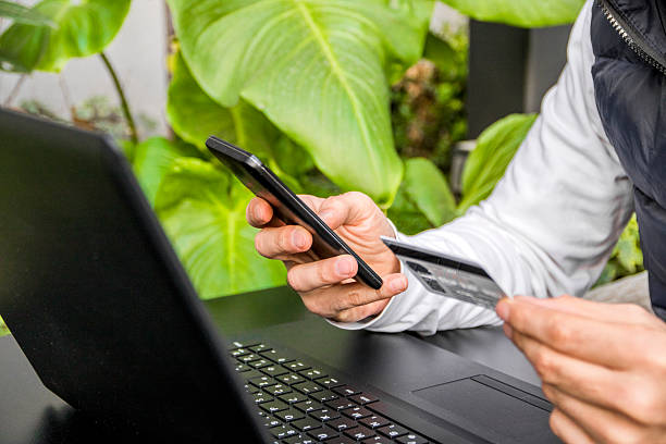 istock Online payment. Man's hands holding a credit card, using smart-phone 625505156