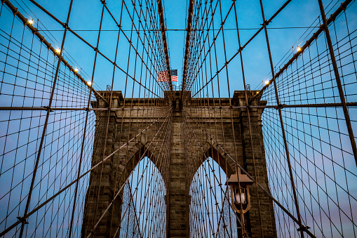Low angle view of arch supports and suspension wires of Brooklyn bridge in Manhattan, New York, USA