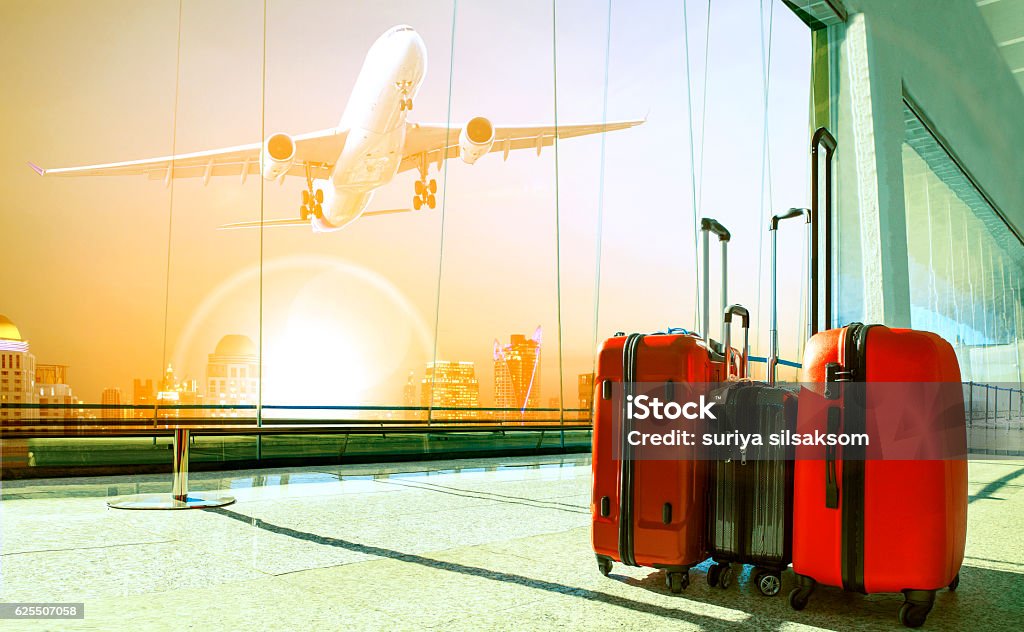 stack of traveling luggage in airport terminal building and pass stack of traveling luggage in airport terminal building and passenger plane flying over urban scene Luggage Stock Photo