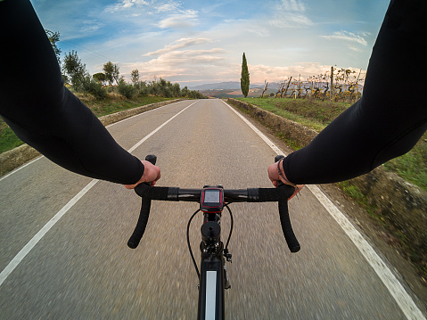 Cyclist personal perspective shot taken with an action camera while cycling on Chianti region hills in Tuscany, Italy.