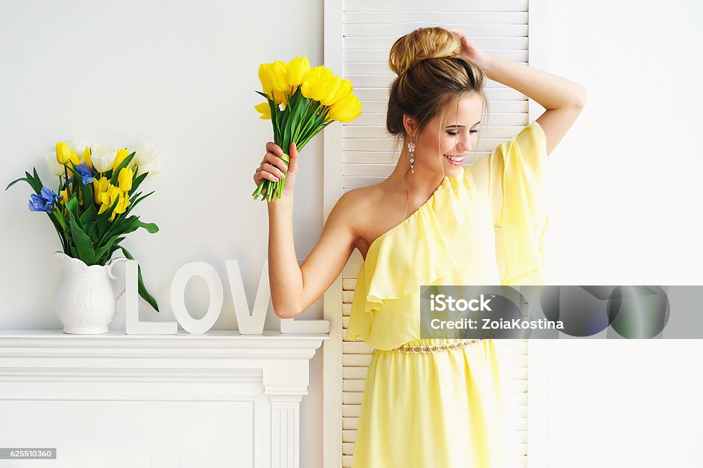 Superbe jeune femme avec tulipes jaunes - Photo de Printemps libre de droits