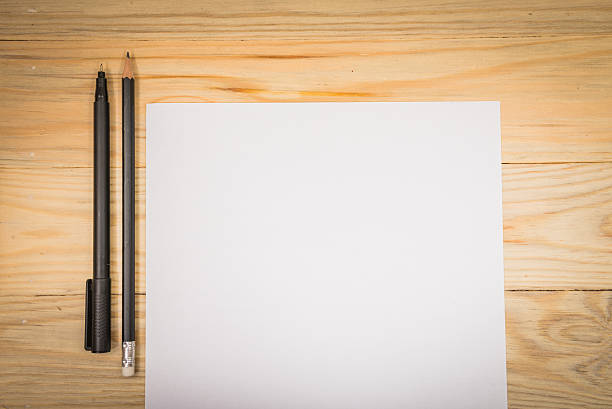 istock Blank white paper with pen on a wooden desk. 625524148