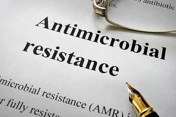 Photo of Paper with words antimicrobial resistance AMR and glasses.