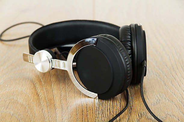istock Headphones and phone on a wooden surface 625527990