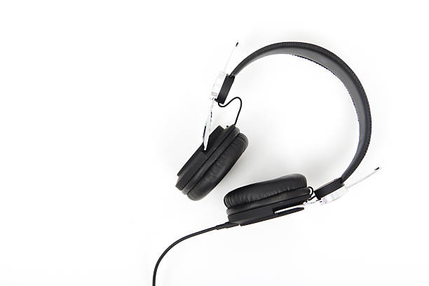 istock Black headphones against a light coloured background 625528084