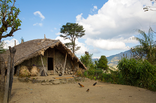 Very simple farm house (still in use) in Mai Chau, North Vietnam. Mountains in the background