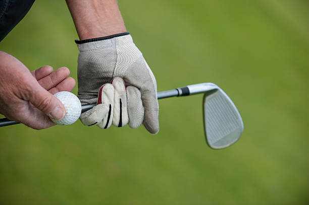 istock Golf club and ball in hand 625529384