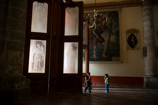 Oaxaca, Mexico - October 31, 2014: Three young boys play inside the Cathedral of Our Lady of the Assumption in the Mexican city of Oaxaca.